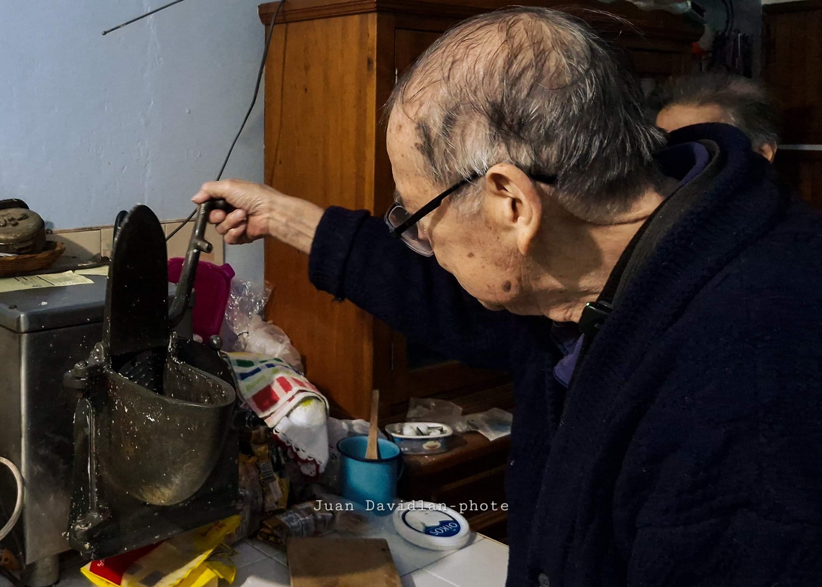 Don Armando triturando coco fresco para los dulces